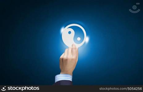 Yin yang icon. Close up of human hand with yin yang concept icon