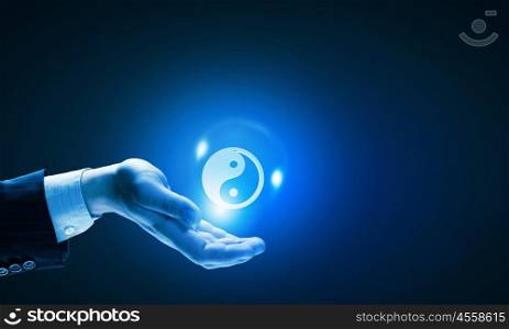 Yin yang philosophy. Close up of businessman holding yin yang symbols in palm