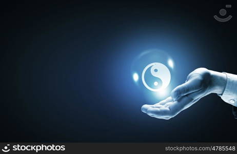 Yin yang philosophy. Close up of businessman holding yin yang symbols in palm