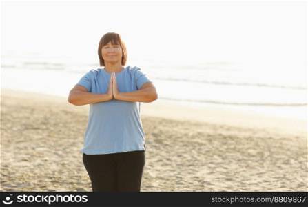 Yoga and meditation of mature woman practicing breath exercises on the sea beach on sunrise in the morning. Body mind and spirit, mindfulness concept. Enlightenment and healthy lifestyle. Yoga and meditation of mature woman practicing breath exercises on the sea beach on sunrise in the morning. Body mind and spirit, mindfulness concept. Enlightenment and healthy lifestyle.