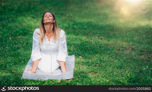 Yoga by the lake, cobra position, soft green background. Yoga by the lake, cobra position