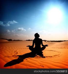 yoga girl in the heart sign on desert sand