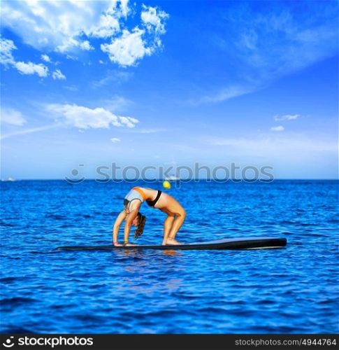 Yoga girl over SUP Stand up Surf board at the ocean sea