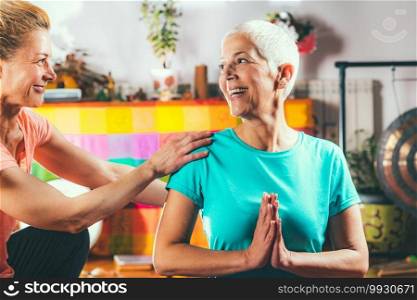 Yoga guru with senior woman, doing yoga