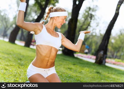 Yoga practice. Young woman in white sitting on grass and practicing yoga