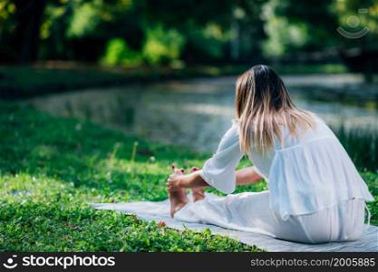 Yoga. Woman doing yoga by the lake, green background. . Yoga. Woman Doing Yoga by the Lake.