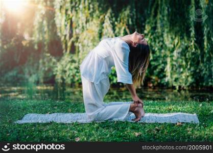 Yoga. Woman doing yoga by the lake, green background. . Yoga. Woman Doing Yoga by the Lake.