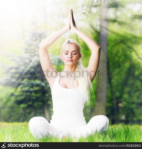 Yoga woman in park. Beautiful young woman in white sportswear doing yoga lotus exercise in park in shiny rays of light