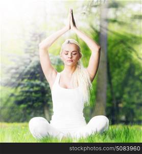 Yoga woman in park. Beautiful young woman in white sportswear doing yoga lotus exercise in park in shiny rays of light