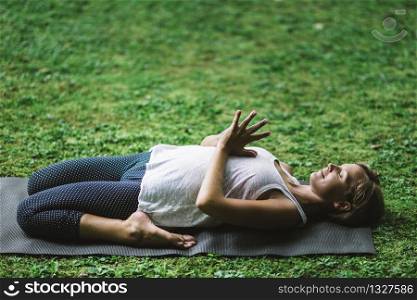 Yoga WOman Meditating, knees bent, hands in prayer position