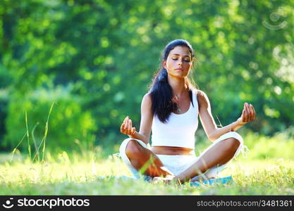 yoga woman on green grass in lotus pose