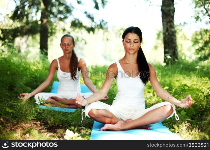 yoga woman on green grass in lotus pose