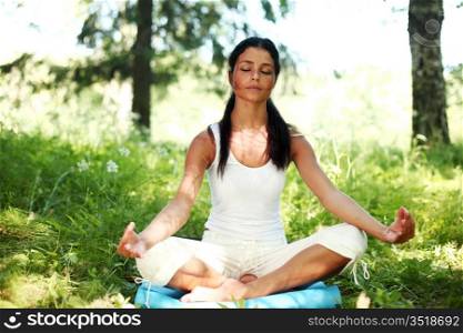 yoga woman on green grass in lotus pose