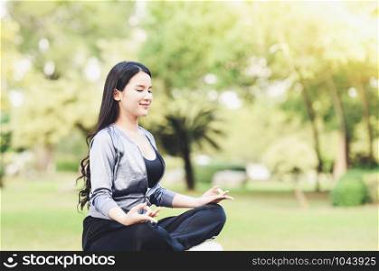 Yoga woman young hand doing yoga and relax meditation on green meadow in park outdoor