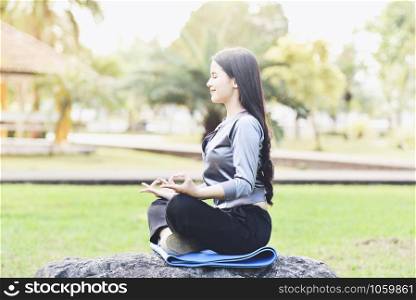 Yoga woman young hand doing yoga and relax meditation on green meadow in park outdoor