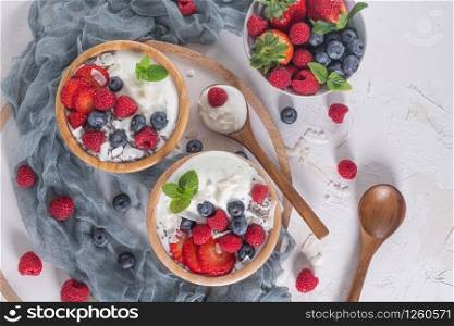 Yogurt and berries for healthy breakfast. Bowl of greek yogurt with raspberry, blueberries and strawberries. Top view