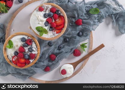 Yogurt and berries for healthy breakfast. Bowl of greek yogurt with raspberry, blueberries and strawberries. Top view