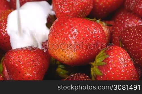 Yogurt flowing on fresh strawberries. Healthy breakfast concept.