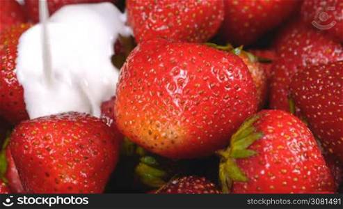 Yogurt flowing on fresh strawberries. Healthy breakfast concept.