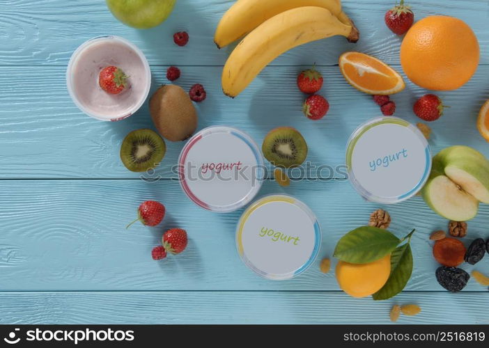 yogurt in a container with tropical fruits on a wooden background, top view. healthy eating concept. dairy products on a blue background