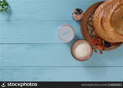 yogurt in a plastic package with a flat cake on a blue wooden background, top view. healthy eating concept. dairy products on a blue background