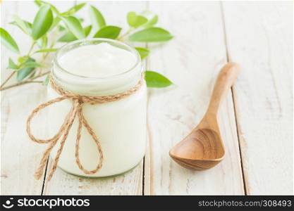 Yogurt in glass bottles on white wooden table Healthy food concept