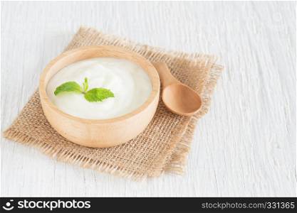 Yogurt in wood bowl on white wooden table Healthy food concept