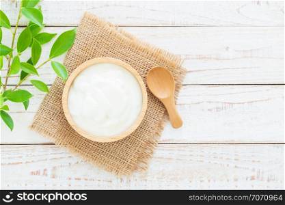 Yogurt in wood bowl on white wooden table Healthy food concept ,top view and copy space