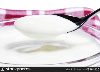 yogurt on a spoon over a yogurt dessert. yogurt on a spoon over a yogurt dessert on a towel on white background
