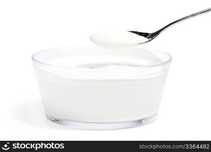 yogurt on a spoon over yogurt in a glass bowl. yogurt on a spoon over yogurt in a glass bowl on white background