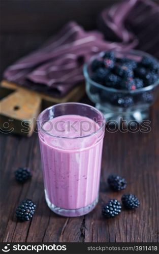yogurt with black barries on the wooden table