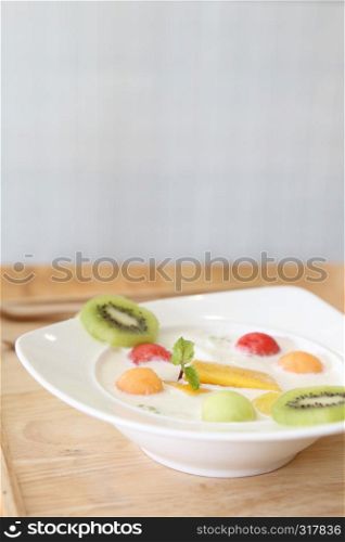 yogurt with fruit on wood background