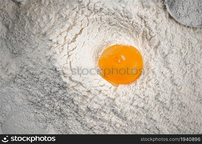 Yolk in a bunch of flour on the table. On a white background. . Yolk in a bunch of flour on the table.