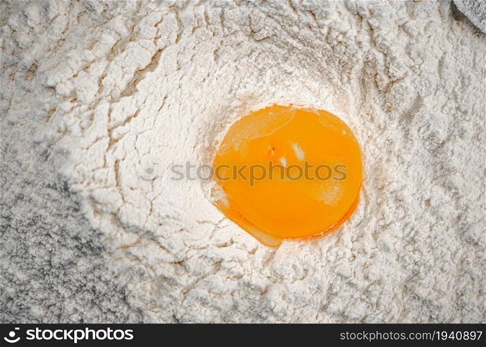 Yolk in a bunch of flour on the table. On a white background. . Yolk in a bunch of flour on the table.