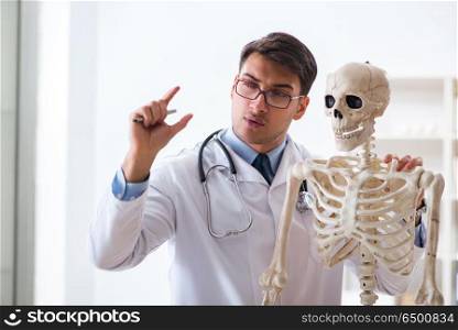 Yong male doctor with skeleton isolated on white