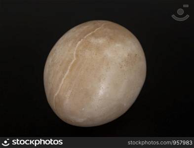 yoni egg in front of black, background