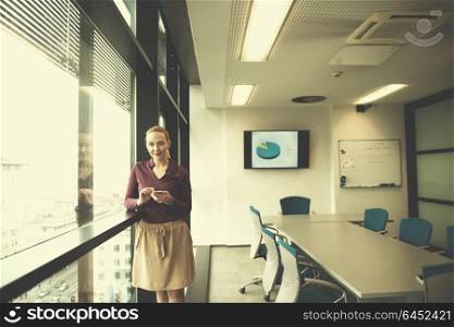 yonug businesswoman in casual hipster clothes using smart phone at modern startup business office meeting room interior