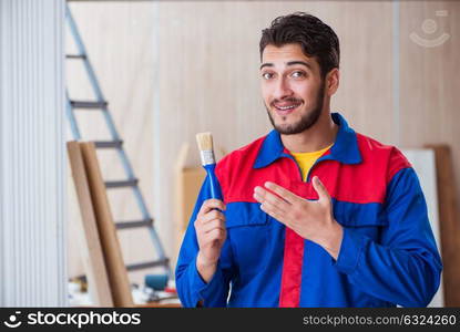 Yooung repairman carpenter working with paint painting