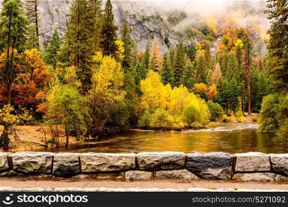 Yosemite National Park Valley and Merced River at autumn. Low clouds lay in the valley. California, USA.