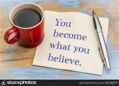 You become what you believe - handwriting on a napkin with a cup of espresso coffee