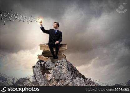 You knowledge is your future!. Handsome businessman sitting on pile of books with mobile phone