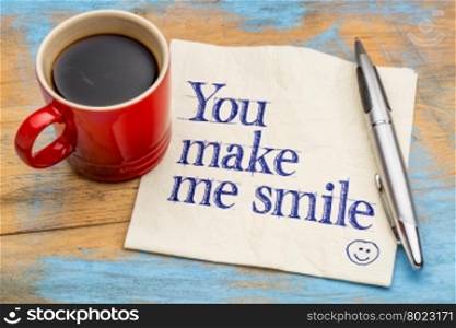 You make me smile - handwriting on a napkin with a cup of coffee