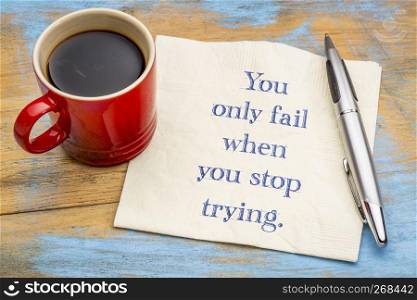 You only fail when you stop trying - handwriting on a napkin with a cup of coffee