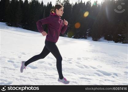 yougn woman jogging outdoor on snow in forest, healthy winter lifestyle and recreation