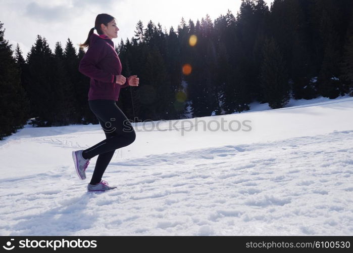 yougn woman jogging outdoor on snow in forest, healthy winter lifestyle and recreation