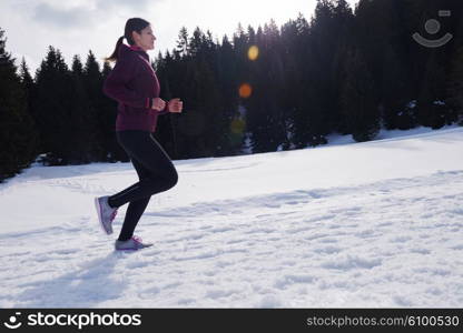 yougn woman jogging outdoor on snow in forest, healthy winter lifestyle and recreation