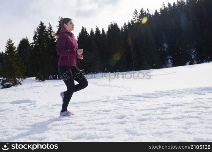 yougn woman jogging outdoor on snow in forest, healthy winter lifestyle and recreation