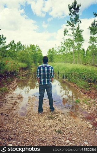 Youn man alone in front of a river
