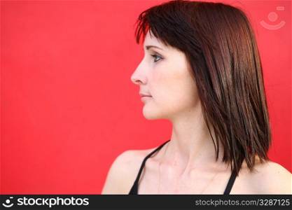 youn pretty girl is posing against red wall