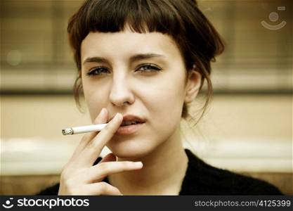 youn woman with cigarette outside,natural soft f/x, urban scene